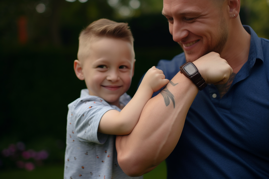 Father building confidence in his young boy by showing him how to flex his bicep